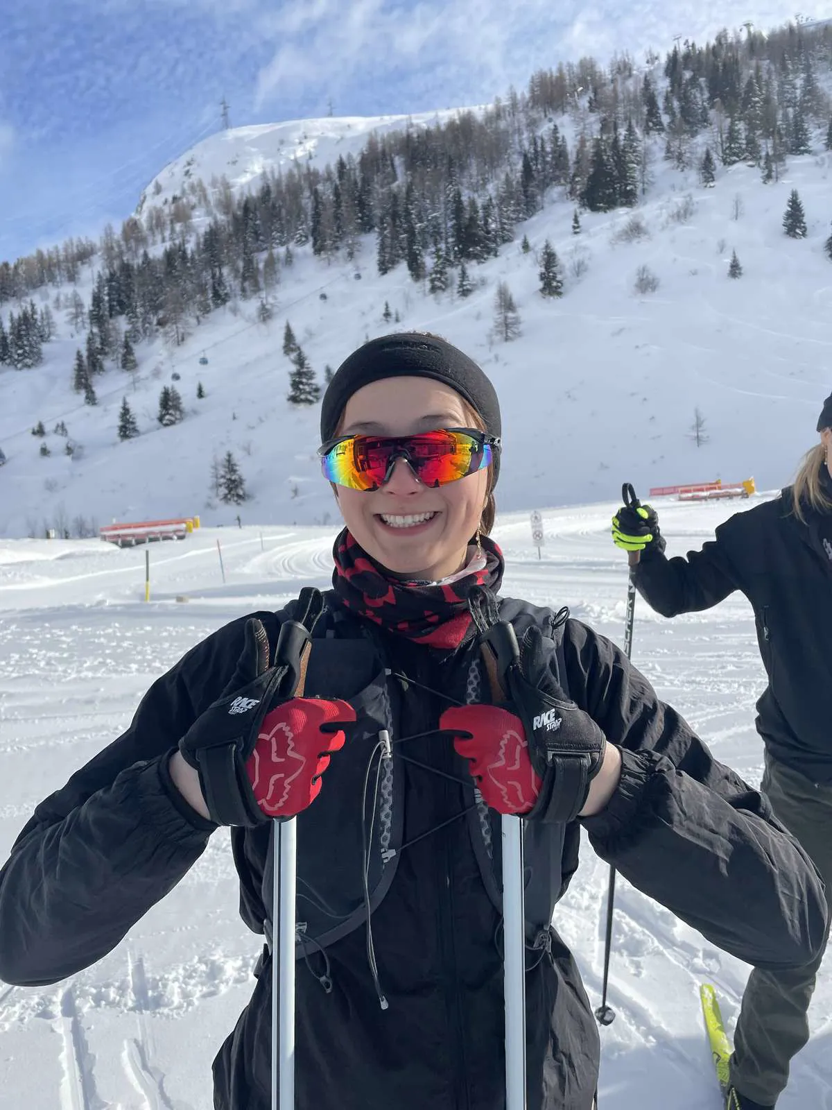 Glad pige med skibriller smilende på pisten