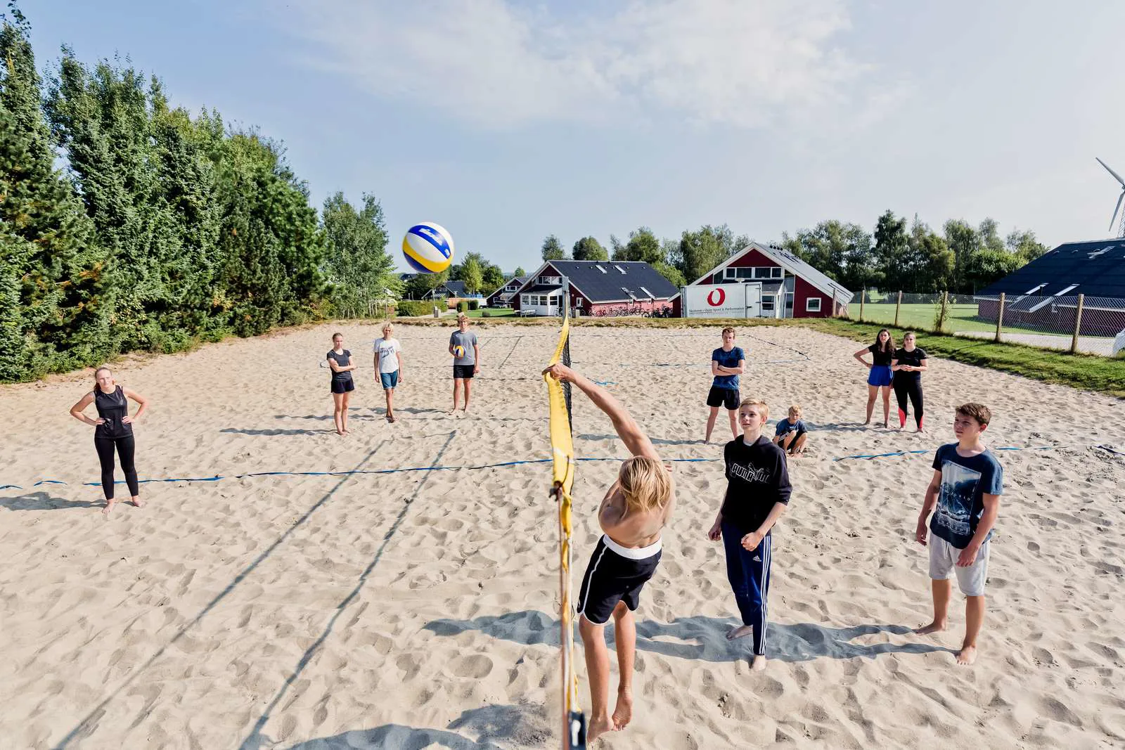 Unge mennesker der spiller beachvolley