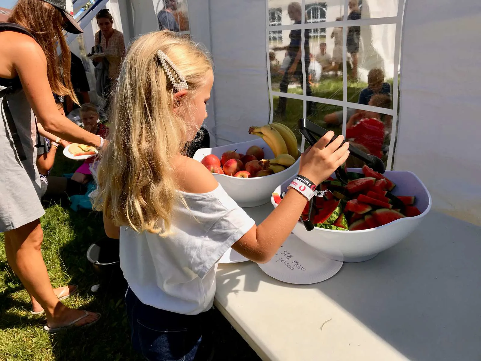 En pige der står og tager frokost på picnic på Egeskov Slot