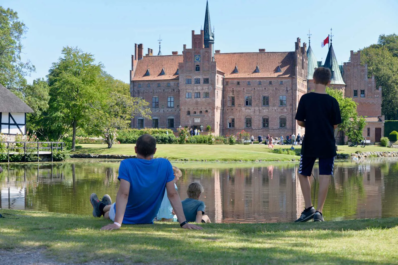 Egeskov Slot i baggrunnden og en far og hans søn i forgrunden