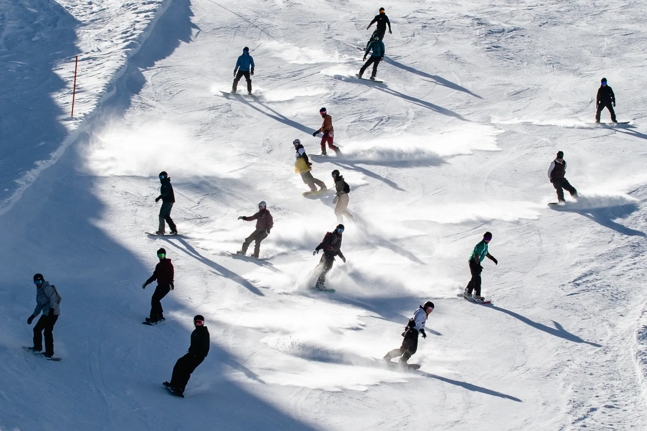En masse elever på vej ned af pisten på snowboards