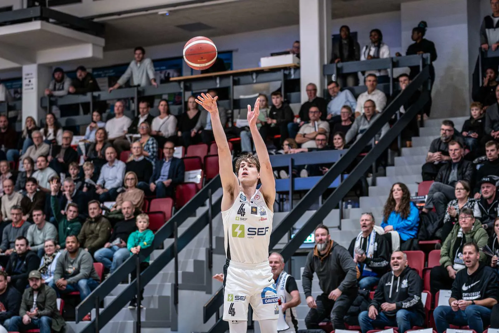 Basketspiller i kamp der skyder mod kurven