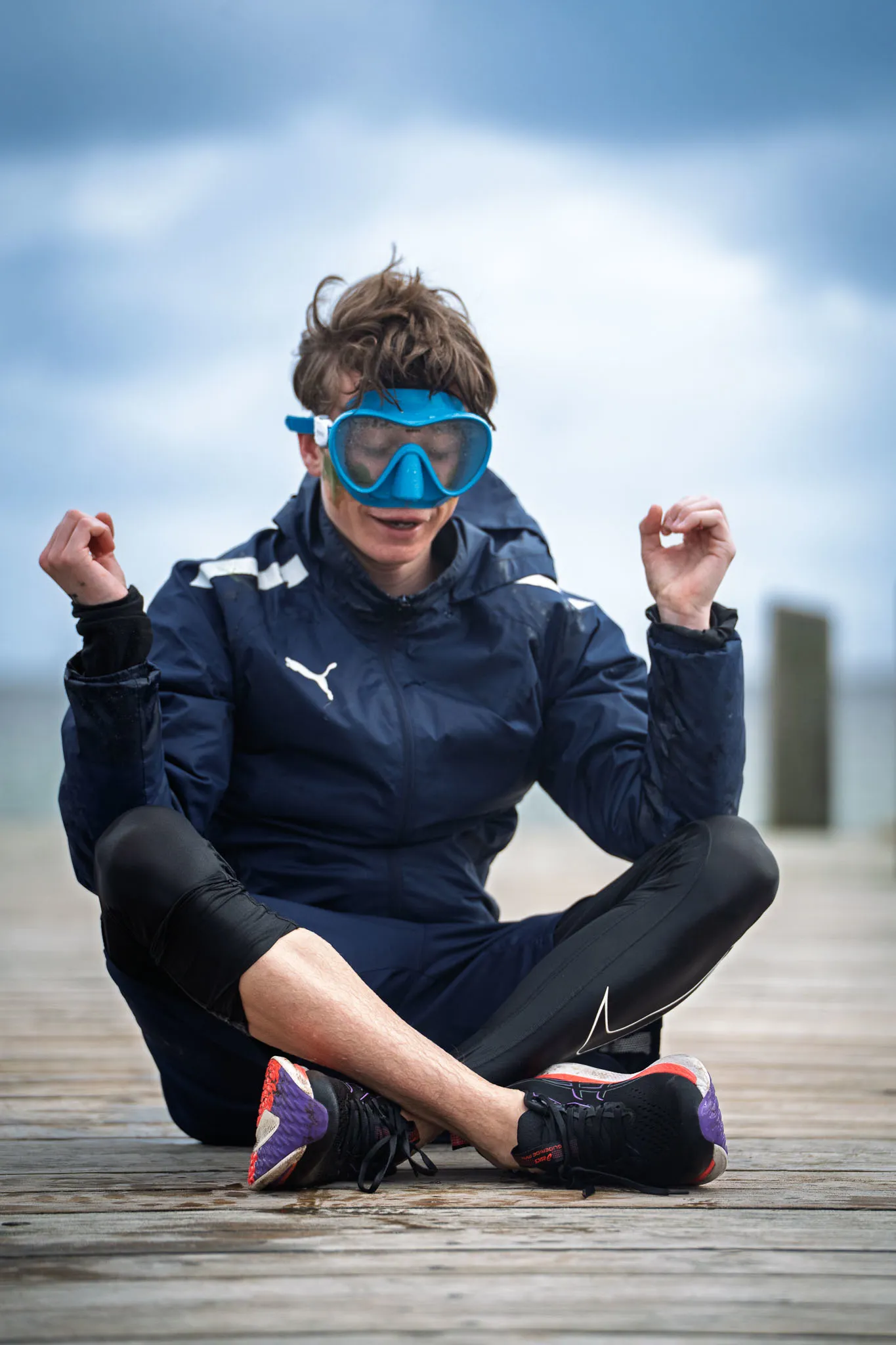 En dreng i yogastilling med dykkerbriller på